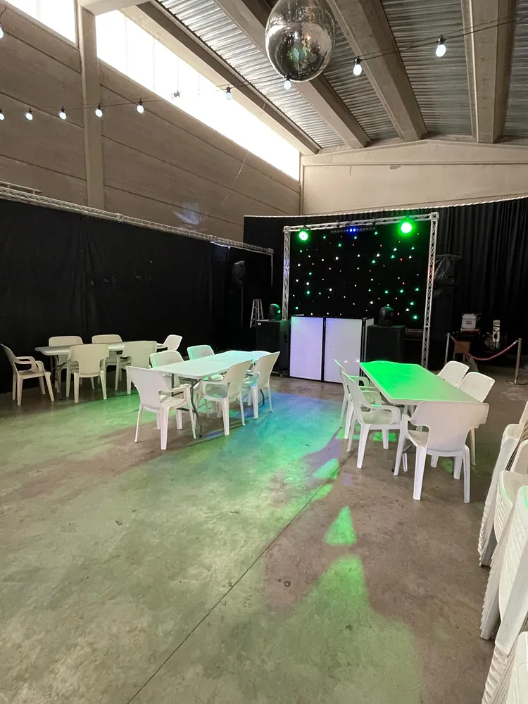 Espacio montado con mesas, sillas y pórtico de luces