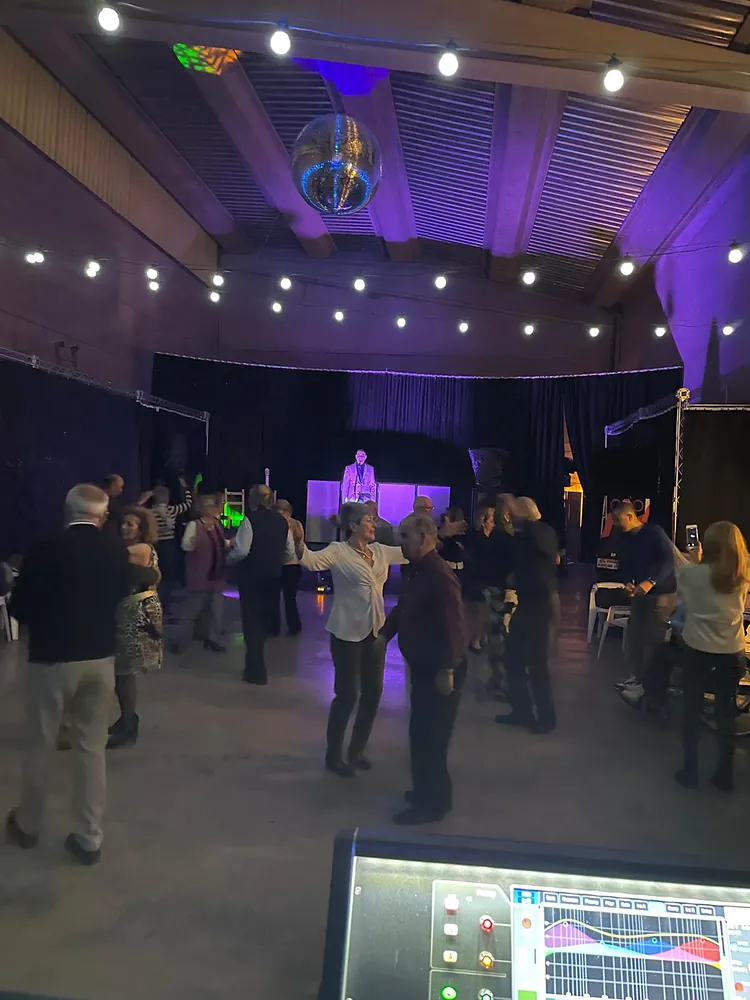 Público bailando en el espacio con iluminación de colores