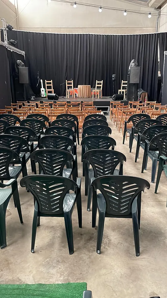 Espacio montado en formato auditorio con sillas frente al escenario