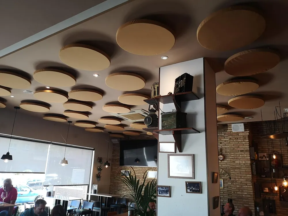 Techo de restaurante con discos acústicos de distintos tamaños para reducir el ruido