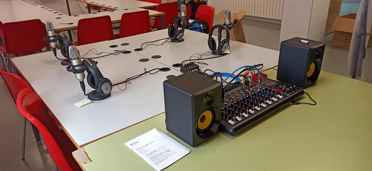 Equipo de radio escolar con cuatro puestos de micrófono y auriculares y mesa de mezclas